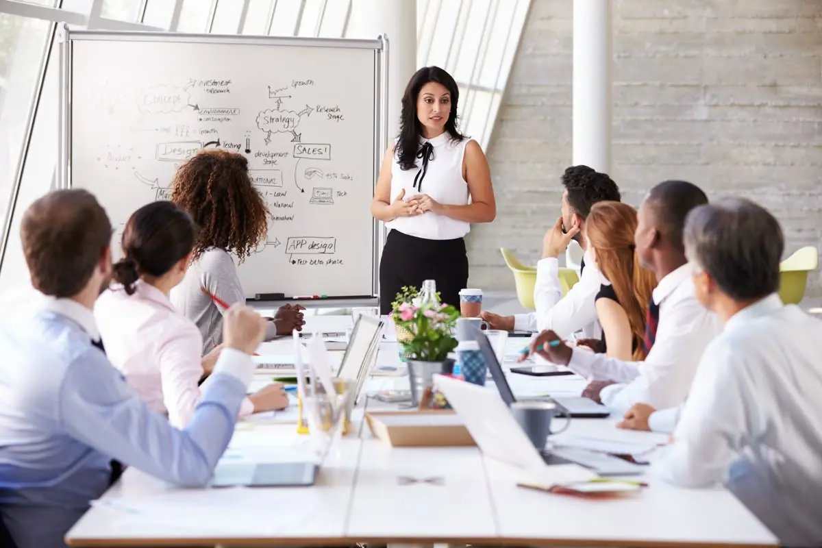 Team in a meeting room with charts or digital whiteboard