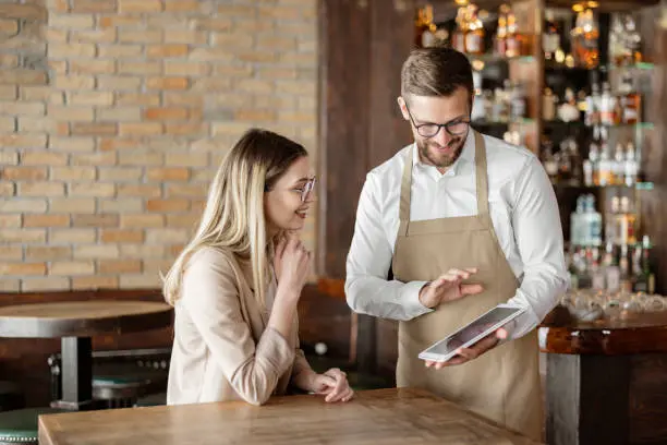 A waiter quickly taking an order on a tablet at a table